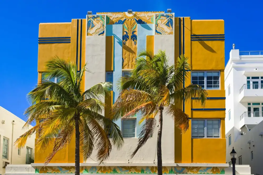 Yellow and white Art Deco building with palm trees in Miami Beach