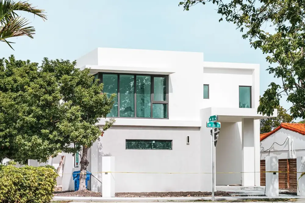 Modern white two-story Miami house with large dark-framed windows
